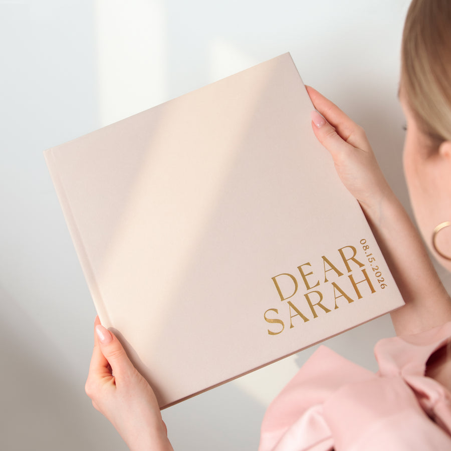 Person holding a beige box with 'Dear Sarah' text on a light background