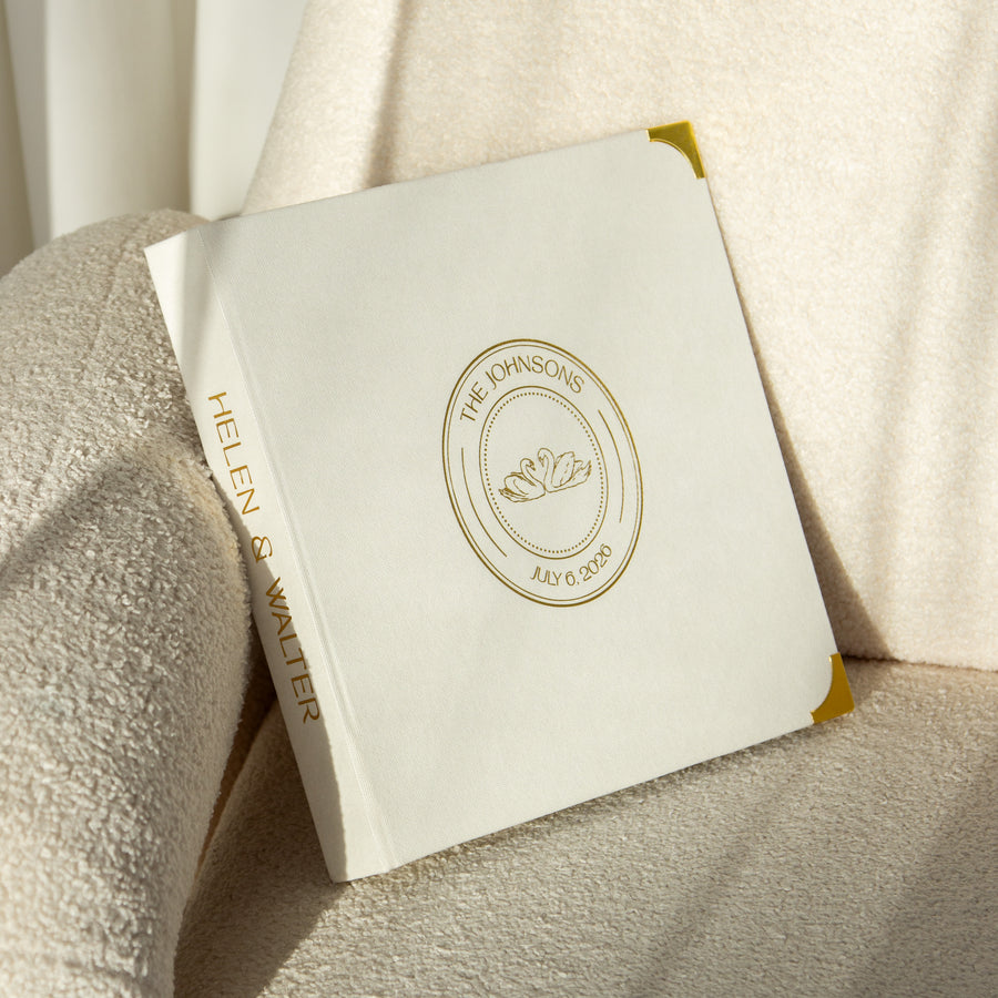 White book with gold embossed design on a textured beige surface