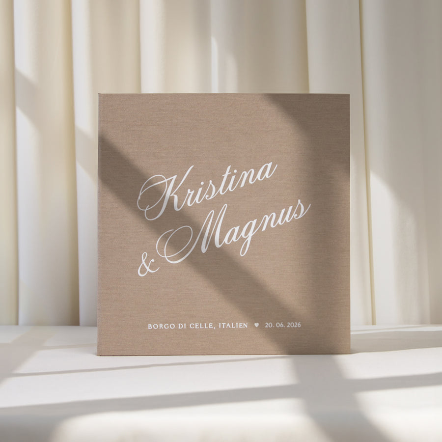Brown linen album with white text 'Kristina & Magnus' on a light background